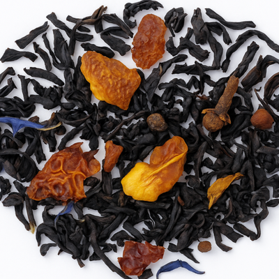 Tea leaves with spices arranged in a circle on a white background