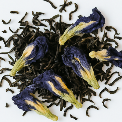 Tea leaves with butterfly pea flowers on a white background, featuring the text 'Faelight Breakfast'.